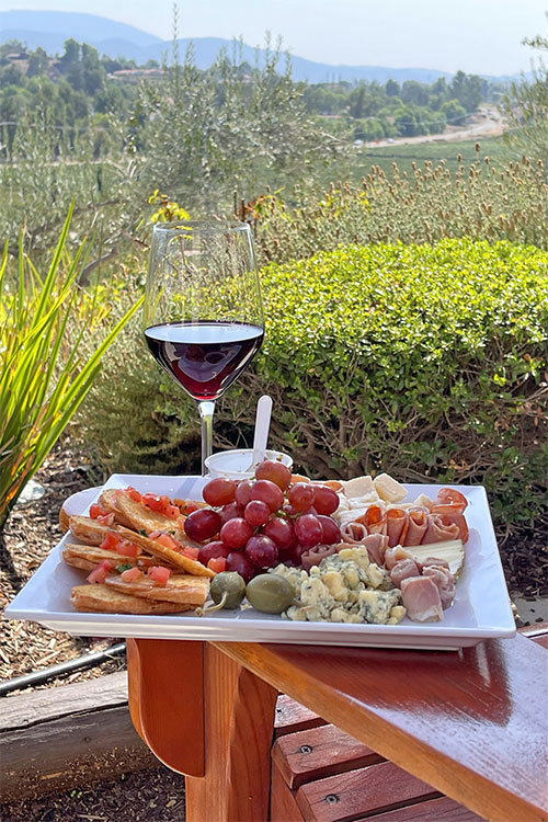 Cougar Winery Glass of red wine and cheese plate